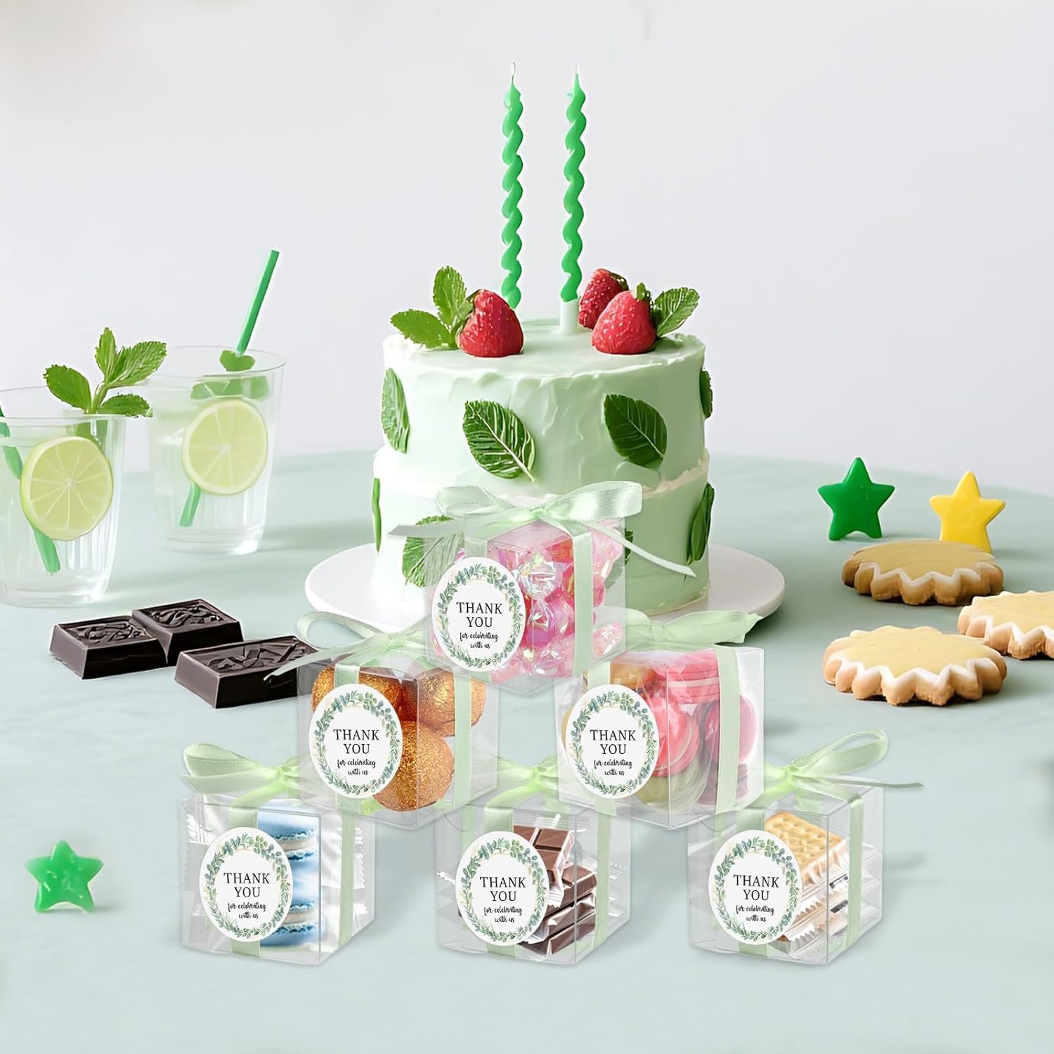 Grossiste de boîtes transparentes à friandises vertes 50 ensembles de 2x2x2 pouces avec logo personnalisé, parfaites pour les cadeaux de retour tels que macarons, bonbons, accompagnées d'un ruban et d'autocollants. Fabricant de décoration pour anniversaire et baby shower. Vente en gros pour vos événements.
